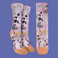 Pair of socks with cat illustrations on a pink background