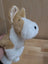A soft plush adorable corgi puppy puppet with tan and white fur and stitched black eyes and nose