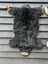 Adorable merino sheepskin bear rug in dark gray with tan paw pads and light brown snout perfect as a black bear decor piece