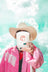 White ceramic candle with red cartoon cowboy hat design in 8oz saddle leather coconut soy candle called assless chaps
