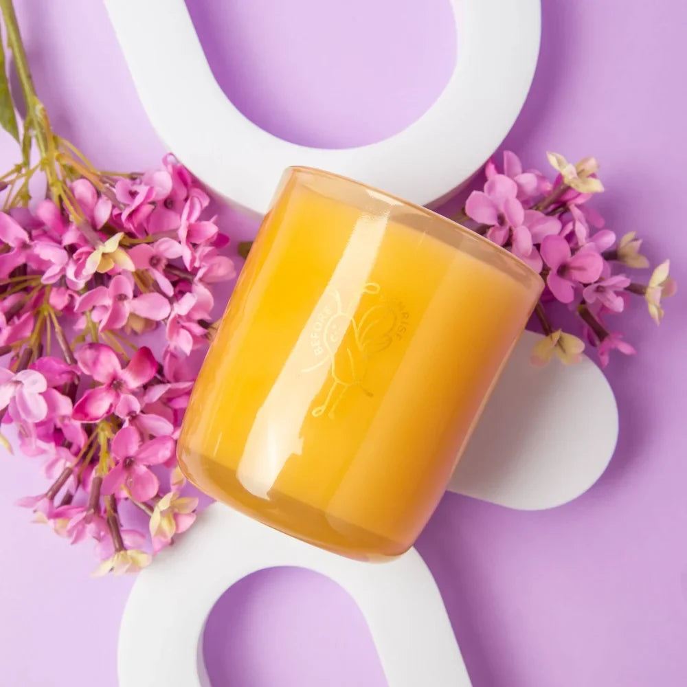 A golden amber glass coconut soy candle jar with subtle floral engraving from angus oliver before sunrise collection