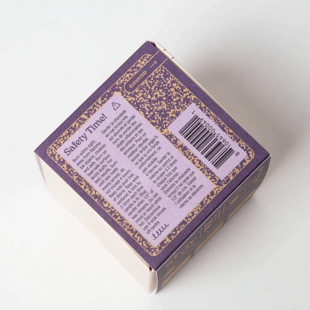 Backside of before sunrise milk and honey coconut soy candle box with purple gold speckles and safety instructions