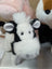 A plush black and white cow toy with fluffy fur soft ears and a rounded snout perfect for kids and decor