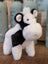 A plush black white cow toy with soft fluffy fur and a giant snuggly muzzle perfect for cuddling