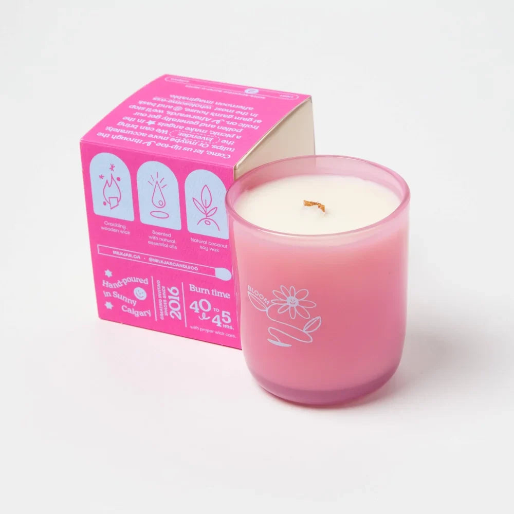 Pink glass bloom candle with white floral design and gold wick made from essential oil coconut soy by angus oliver