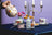 White ceramic teapot with floral design pouring blueberry tea over cup next to angus oliver blueberry tea reed diffuser