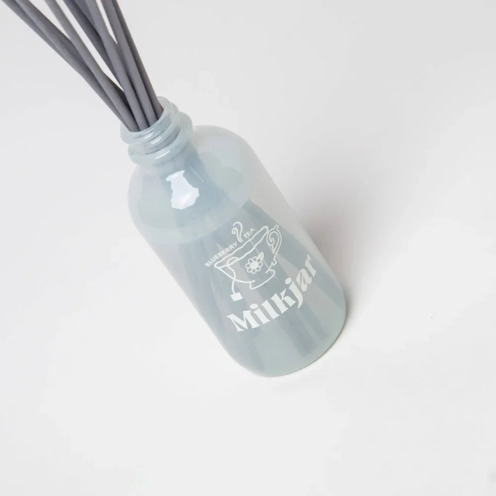 Gray frosted glass milkjar reed diffuser with blueberry tea scent and gray reeds by angus oliver