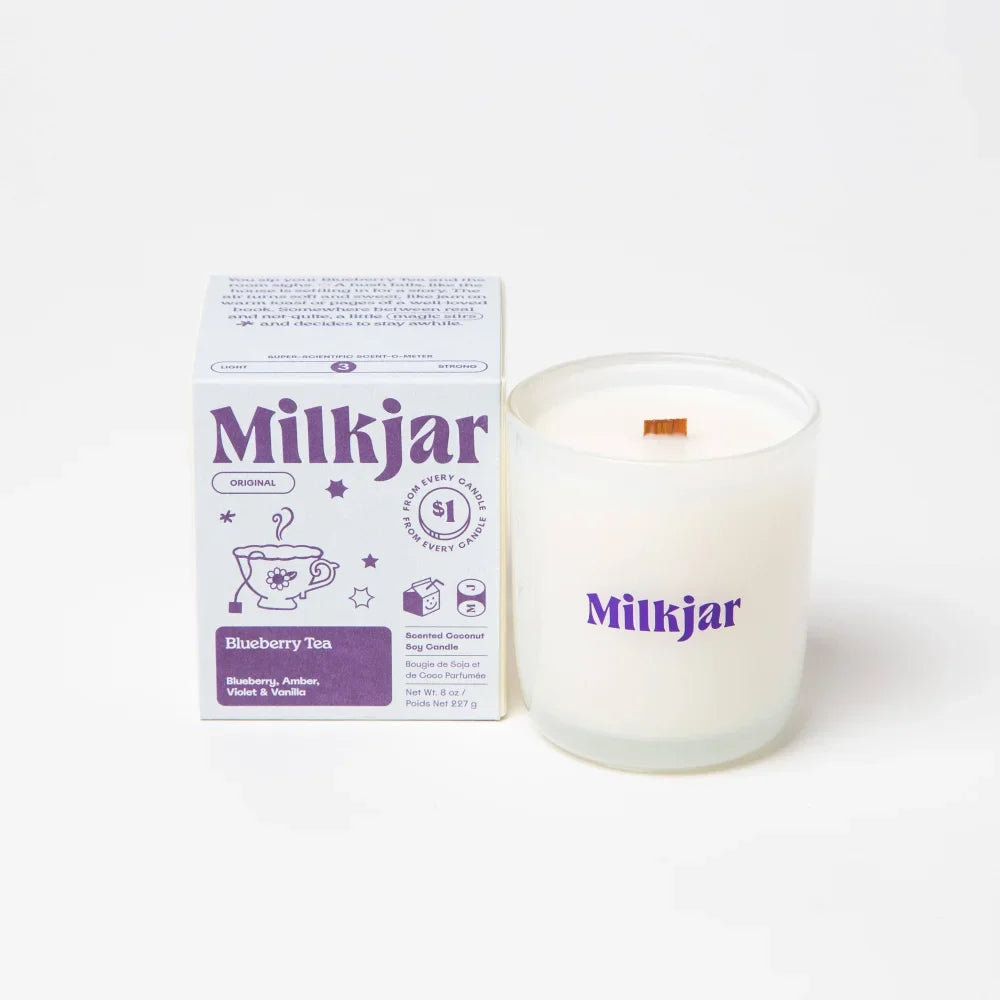 Blueberry tea coconut soy wax candle in a white glass jar with wooden wick and purple branding
