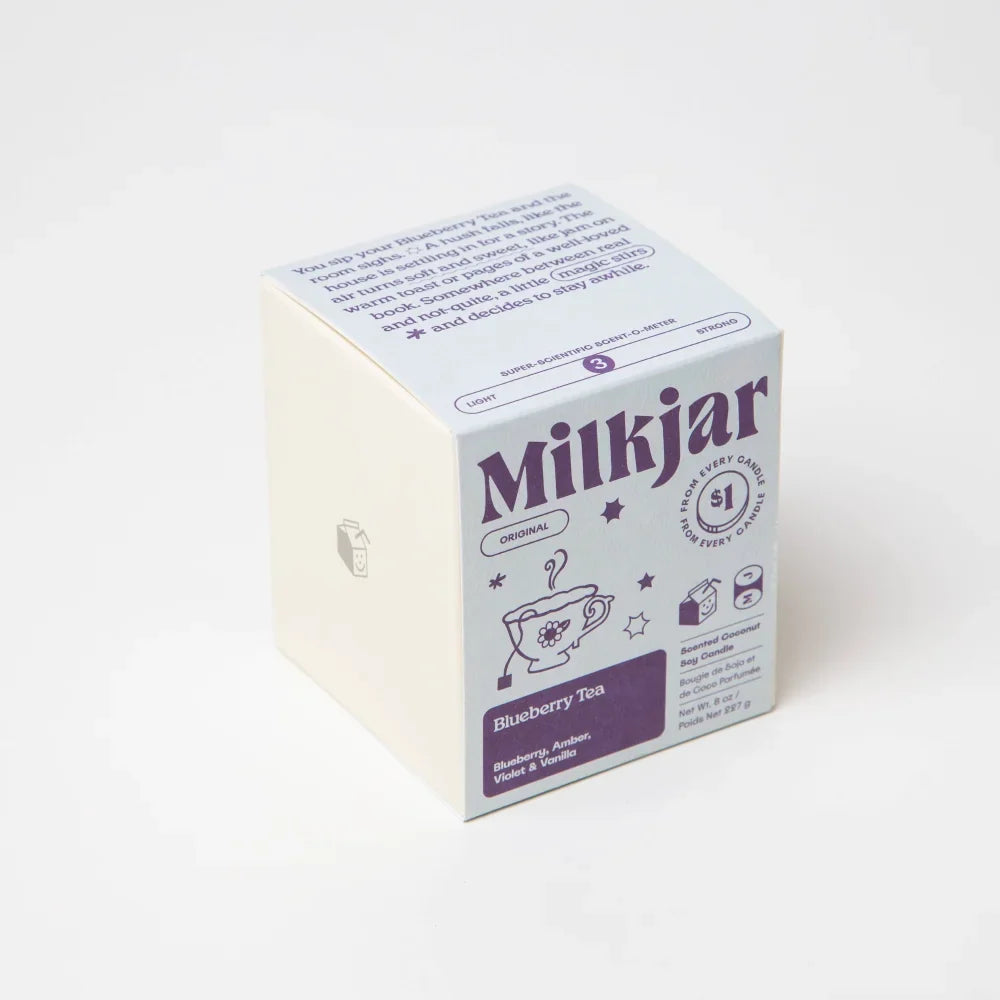 White cardboard box of milkjar original blueberry tea coconut soy wax candle with purple and gray text and illustrations