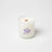 A white blueberry tea scented coconut soy wax candle with wooden wick in a frosted jar with a purple tea cup design