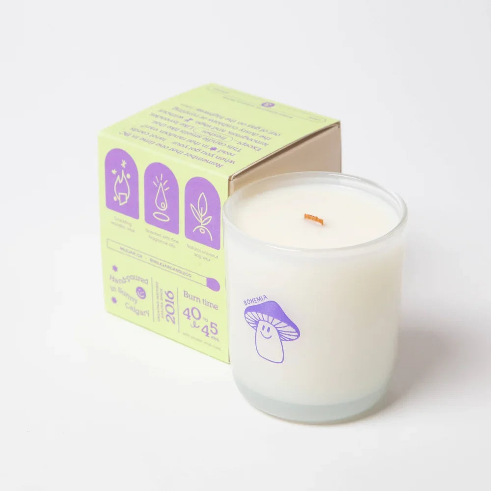A white coconut soy wax candle in a clear glass jar with a purple mushroom logo branded sohma bohemia lemongrass lavender sage