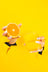 A vibrant yellow glass mug printed with milk held against yellow background next to citrus essential oil coconut soy candle