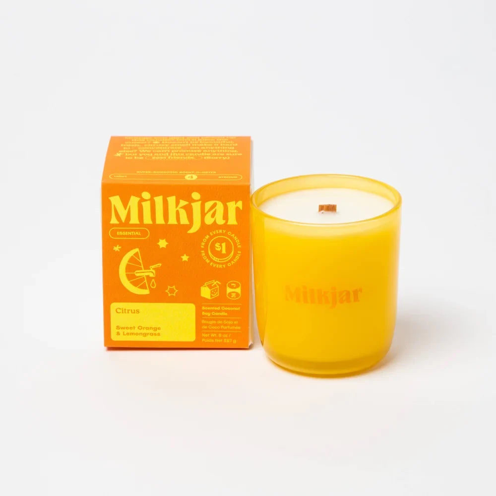 Vibrant yellow milkjar citrus scented essential oil candle in translucent glass jar made with coconut soy blend