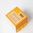 Orange cardboard box with yellow border showing safety instructions for citrus essential oil coconut soy candle 8oz back side