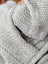 Close-up of cream woolen calgary cardigan with light gray chunky-knit zealand wool and soft fleece zipper pull detail