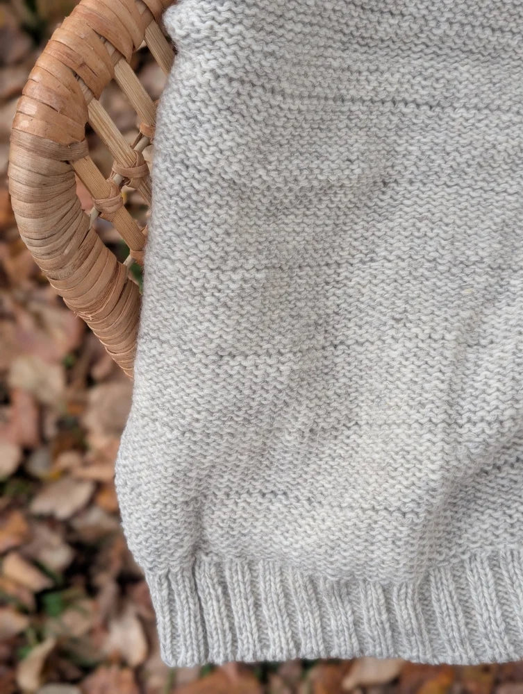 Cream woolen calgary cardigan featuring a soft fleece light gray knit with textured pattern and ribbed hem made from zealand wool
