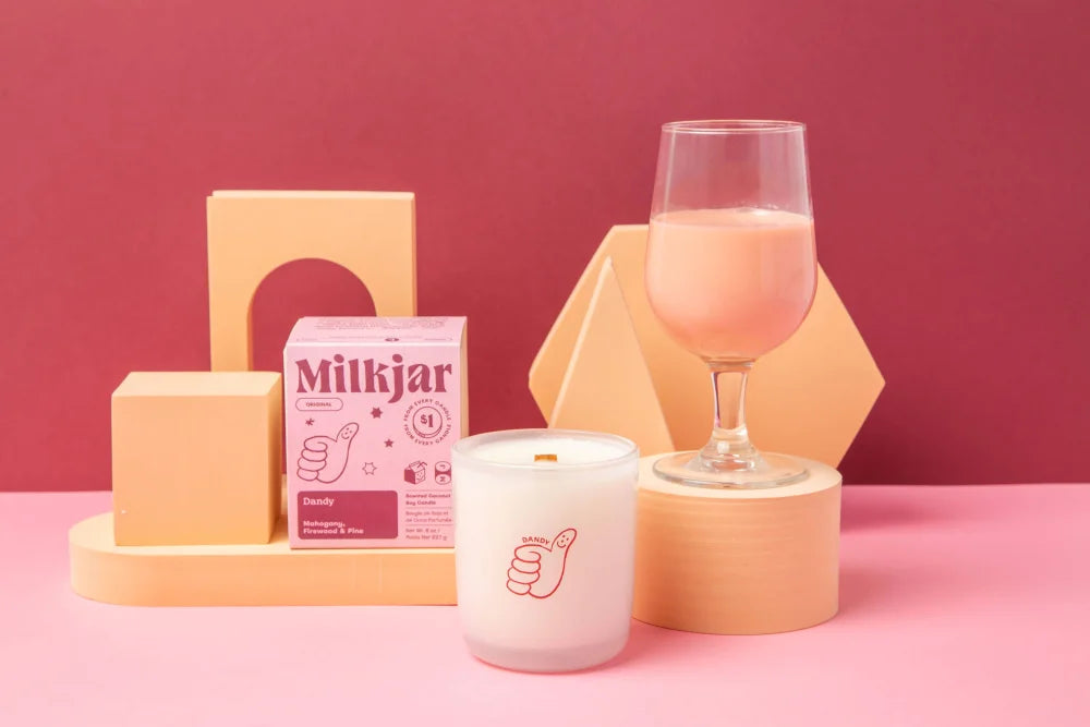 A white coconut soy candle in frosted glass with a red thumbs-up logo from angus oliver dandy collection
