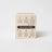 Beige cardboard box showing the back of dandy mahogany firewood pine coconut soy 8oz candle with care instructions
