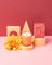 A peach-colored glass jar candle with white coconut soy wax and gold milkjar logo darjeeling patchouli santal scent