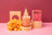 A peach-colored darjeeling patchouli santal coconut soy candle in a clear jar with gold lettering and wooden wick
