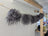 Dark grey sheepskin pom pom with gray curly wool on wooden stick