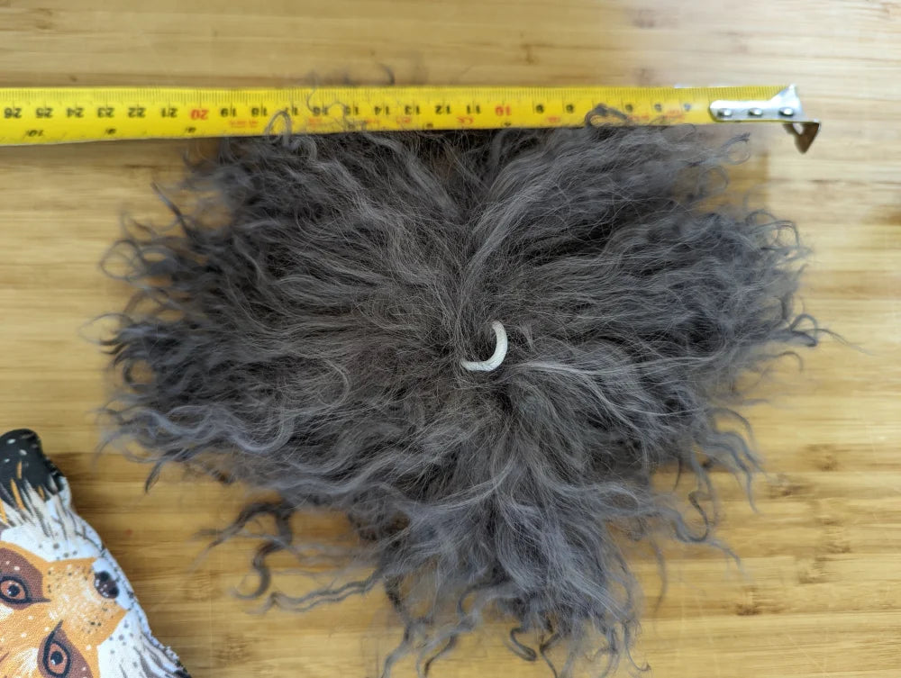 Dark grey sheepskin pom pom with grey curly hair extension and white band