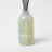 Translucent green glass reed diffuser bottle with dark gray sticks fresh laundry scent featuring french vanilla by angus oliver