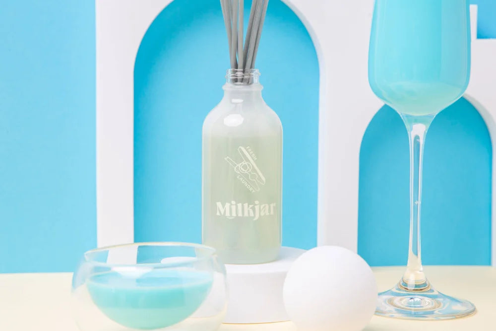 A frosted glass fresh laundry reed diffuser with minimal milkjar branding featuring french vanilla scent by angus oliver