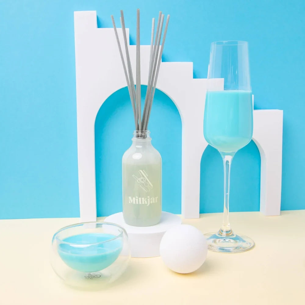 A frosted glass mittijar reed diffuser bottle with silver logo and gray sticks holding light green fresh laundry scent