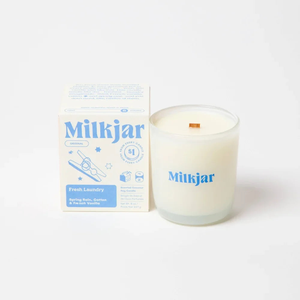 A creamy white fresh laundry milkjar candle with wooden wick in a clear glass jar by angus oliver perfect for cowhide rugs