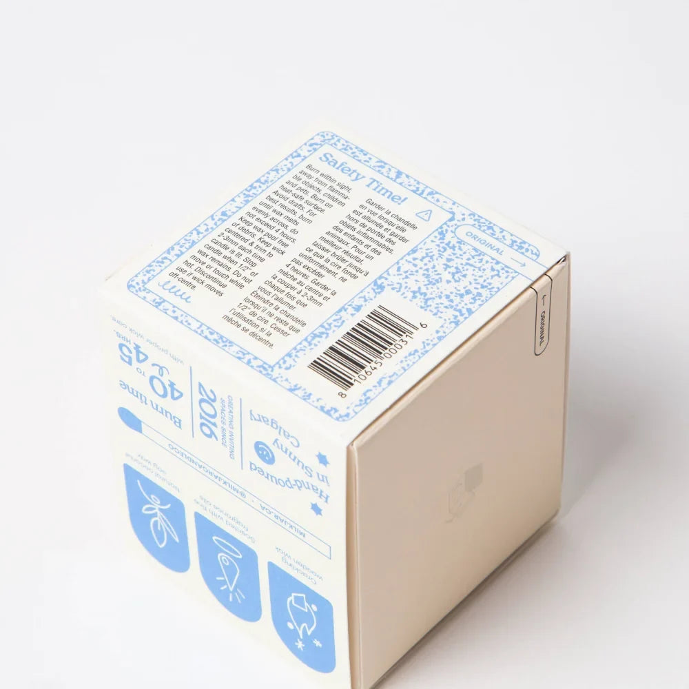Beige cardboard box with blue floral border and safety instructions on the back for angus oliver french vanilla candle