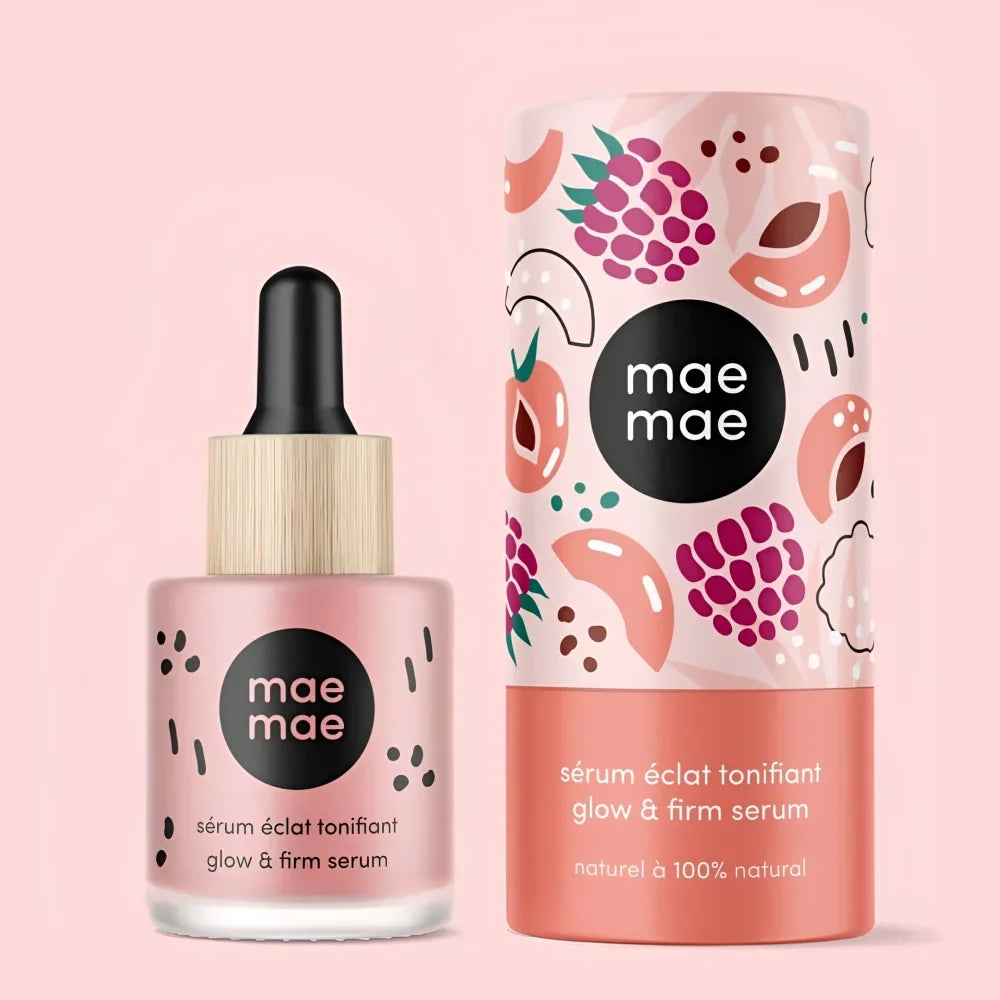 Pink glass bottle with black dropper and bamboo cap mae mae glow and firm serum next to illustrated tube packaging with seed oil