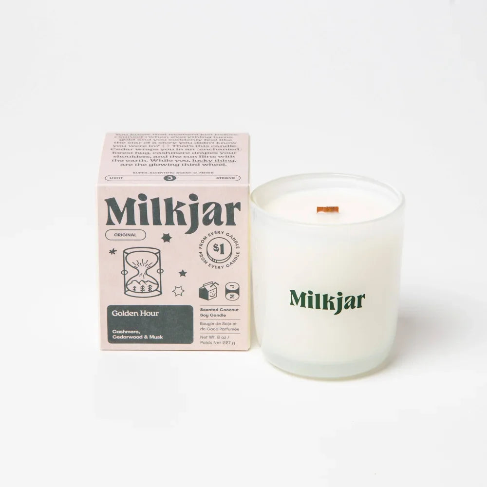 A frosted glass milkjar candle with white coconut soy wax and wooden wick labeled golden hour cashmere cedarwood coconut soy