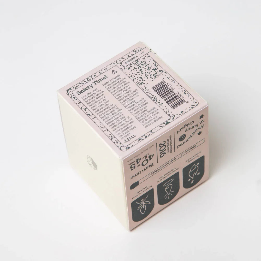 Pastel pink candle box with black speckles featuring golden hour cashmere cedarwood coconut soy wax 8oz candle details
