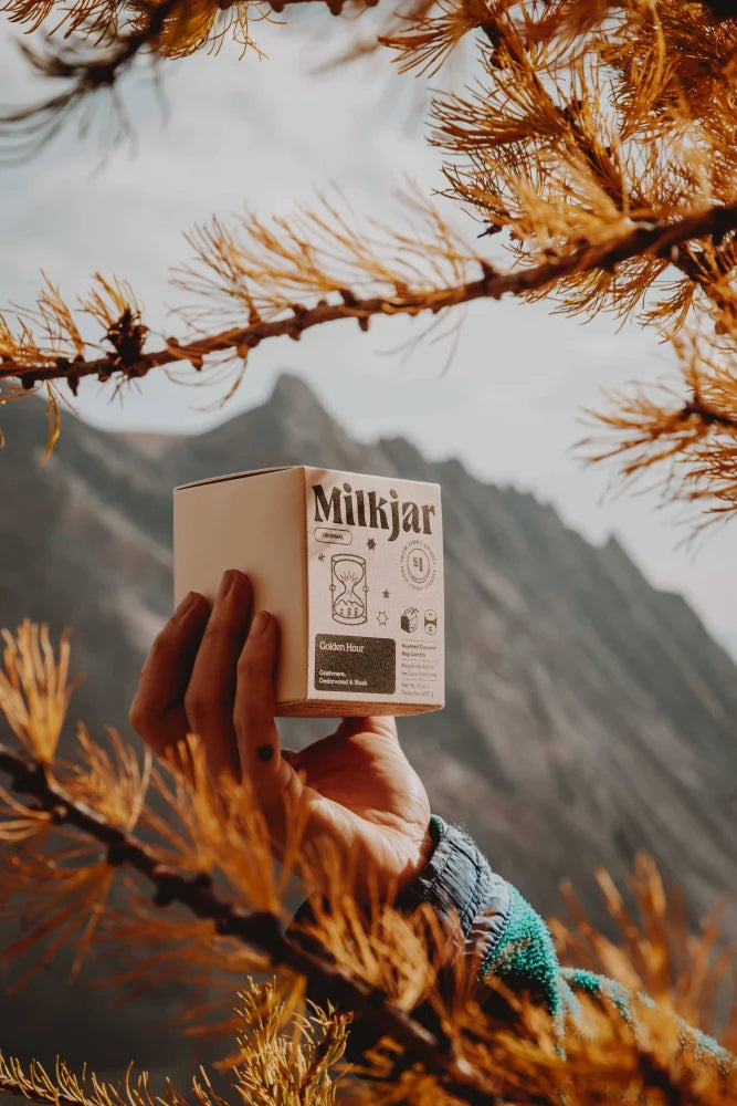 A beige cardboard box labeled milkjar with minimalist black and white branding for golden hour coconut soy wax candle
