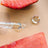 Clear glass dropper with a bulbous tip holding a drop of hydrate and purify oil serum with strawberry seed oil