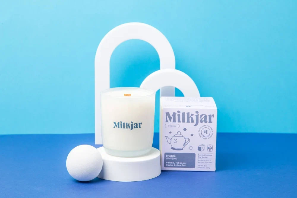 White milkjar coconut soy candle in a clear glass jar with minimalist design and hygge branding on the side