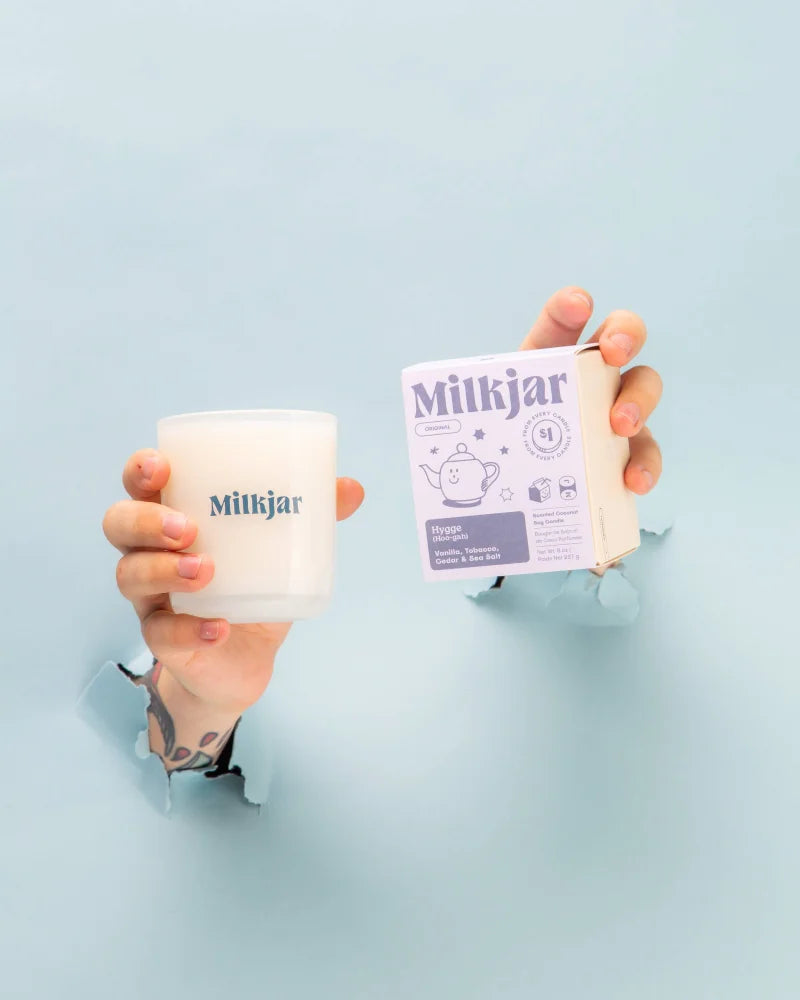 White milkjar coconut soy candle in frosted glass jar with hygge vanilla tobacco and cedar label on the side