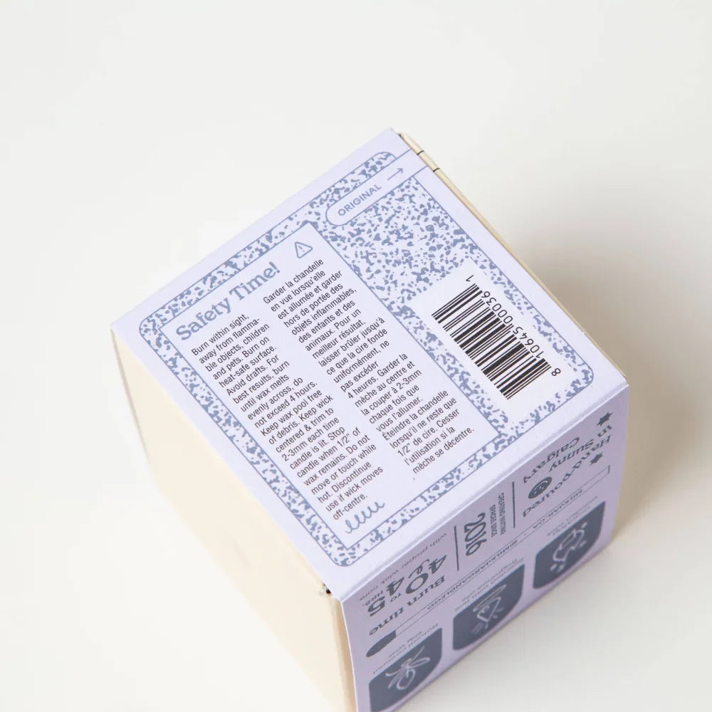 Back of white speckled cardboard box with barcode and safety info for hygge vanilla tobacco cedar coconut soy candle