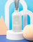 A frosted glass milkjar reed diffuser with a white etched teapot logo and gray reeds for vanilla tobacco sea salt scent