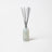 A sleek translucent light gray glass reed diffuser bottle with silver sticks for vanilla tobacco and sea salt scent