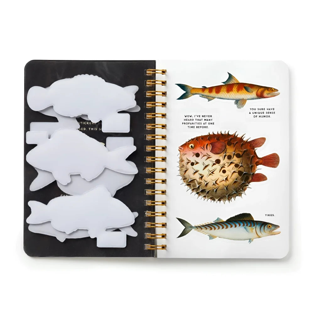 White fish-shaped sticky notes in black holder next to open judgy fish sticker book with illustrated fish pages