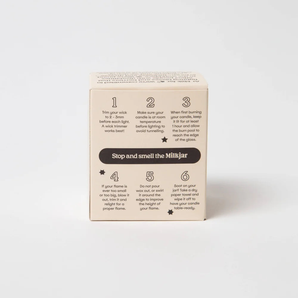 Beige cardboard box with black text and dark brown banner showing candle care for lemonade coconut soy 8 oz candle back side