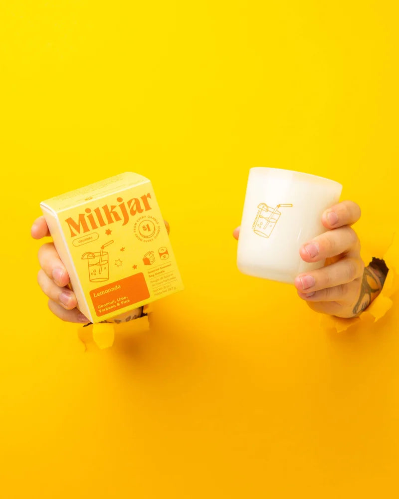 A white frosted glass coconut soy candle jar with gold lemonade and straw illustrations for a tropical scent