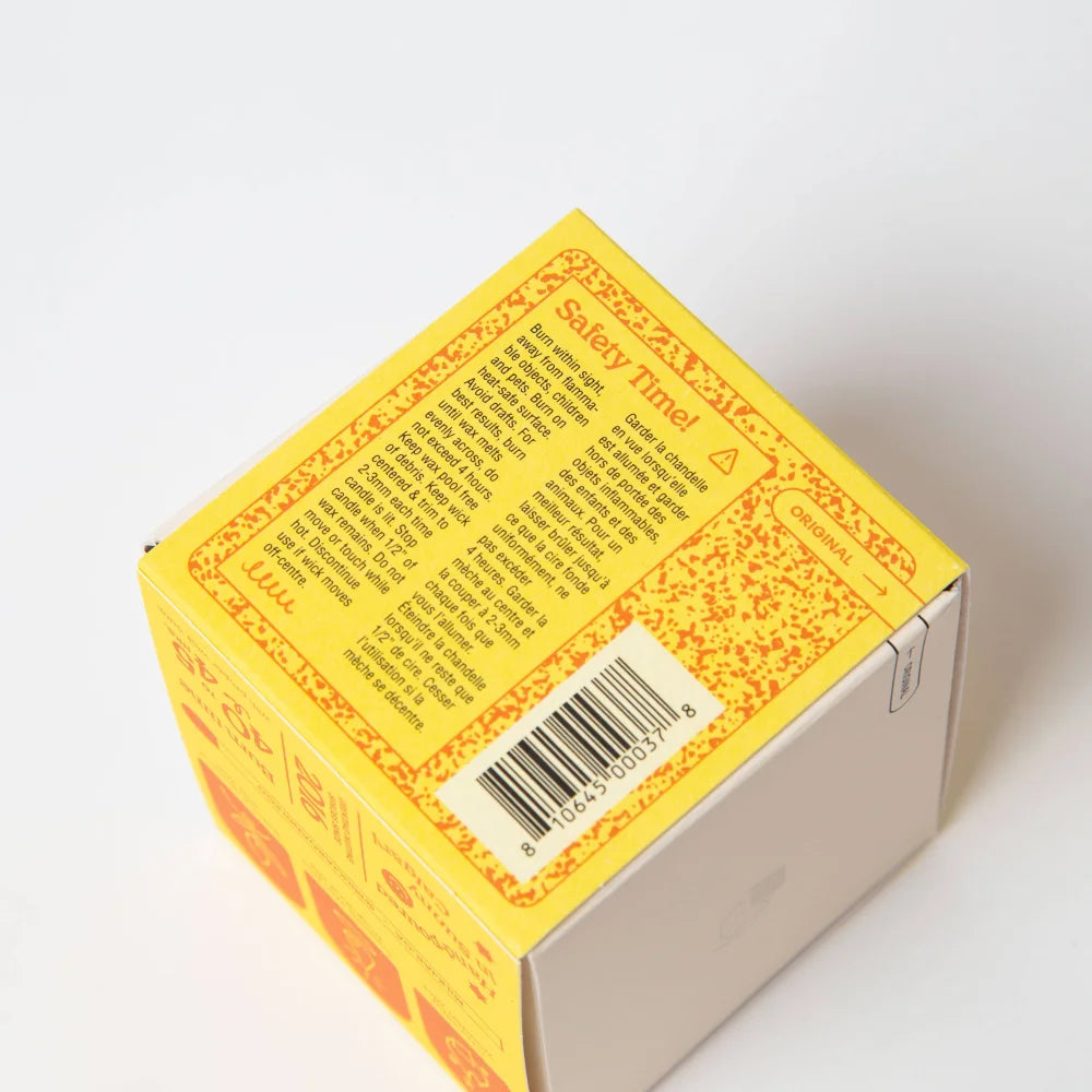 Yellow cardboard box with orange speckled pattern showing safety instructions for lemonade coconut soy candle