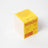 Bright yellow cardboard box for coconut soy lemonade candle with orange text and drink illustration on front