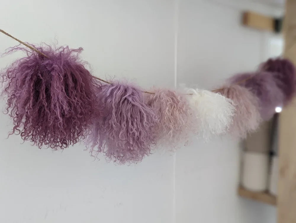 Medium pink sheepskin pom pom garland with lavender white fur and rustic wood handle