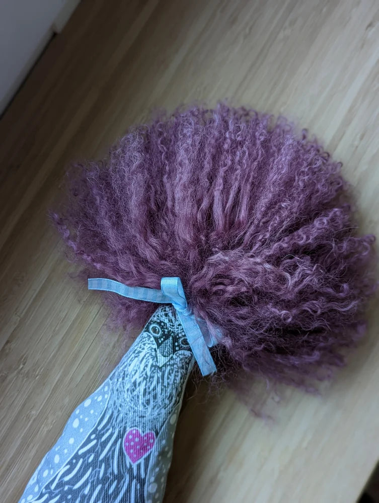 Medium pink sheepskin pom pom with lavender fluff on heart fabric