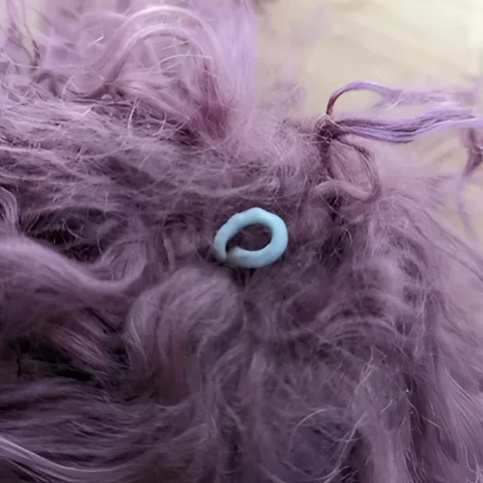 Medium pink sheepskin pom pom with lavender fur and turquoise eye bead