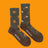 A pair of olive green and brown merino wool socks with orange tree stumps and axes perfect for hiking and trails